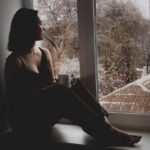 Ung kvinde kigger ud af vinduet